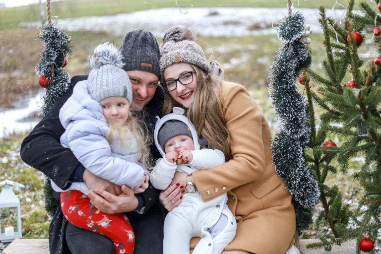 Rodzina na huśtawce pozuje do zdjęcia świątecznego